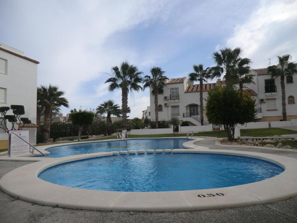 una grande piscina di fronte a un edificio di Casas Holiday - Golf Willamartin a Villamartin