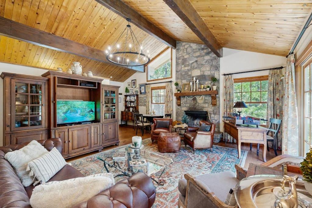 a large living room with a couch and a tv at Treetop Cottage in Running Springs