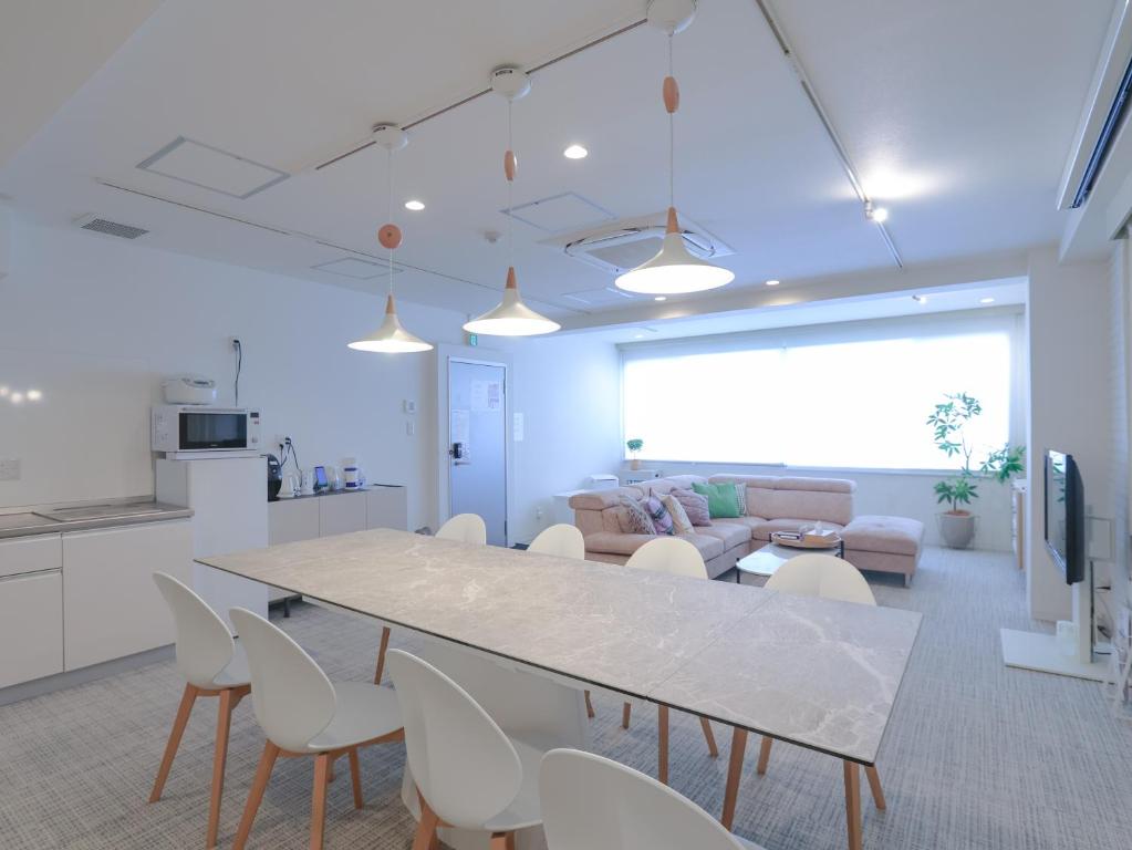 a kitchen and living room with a large table and chairs at INOVE VILLA OSAKA -120m2 , 7 Double Beds , 2 BR , 2 Bath , Easy Access to Umeda , Kyoto ーPerfect for Families & Groupsー in Osaka