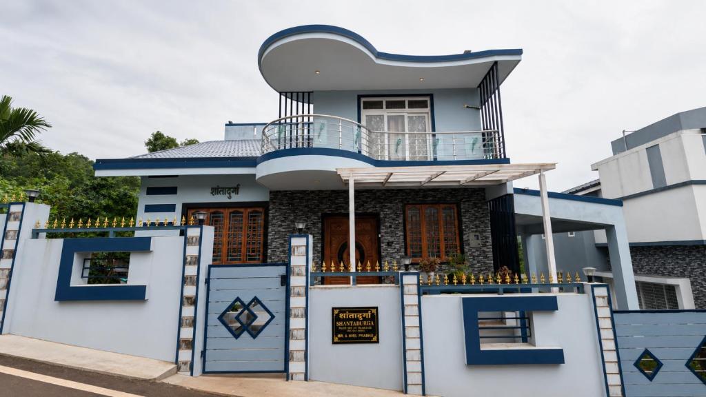 a house with a balcony on top of it at Mrinal Homestay in Ponda