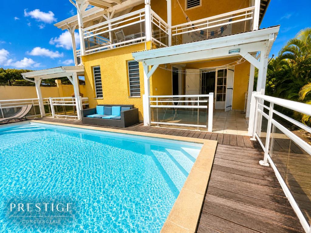 a house with a swimming pool in front of a house at Petit Havre de Paix BIS - Piscine et plage à pied in Le Gosier