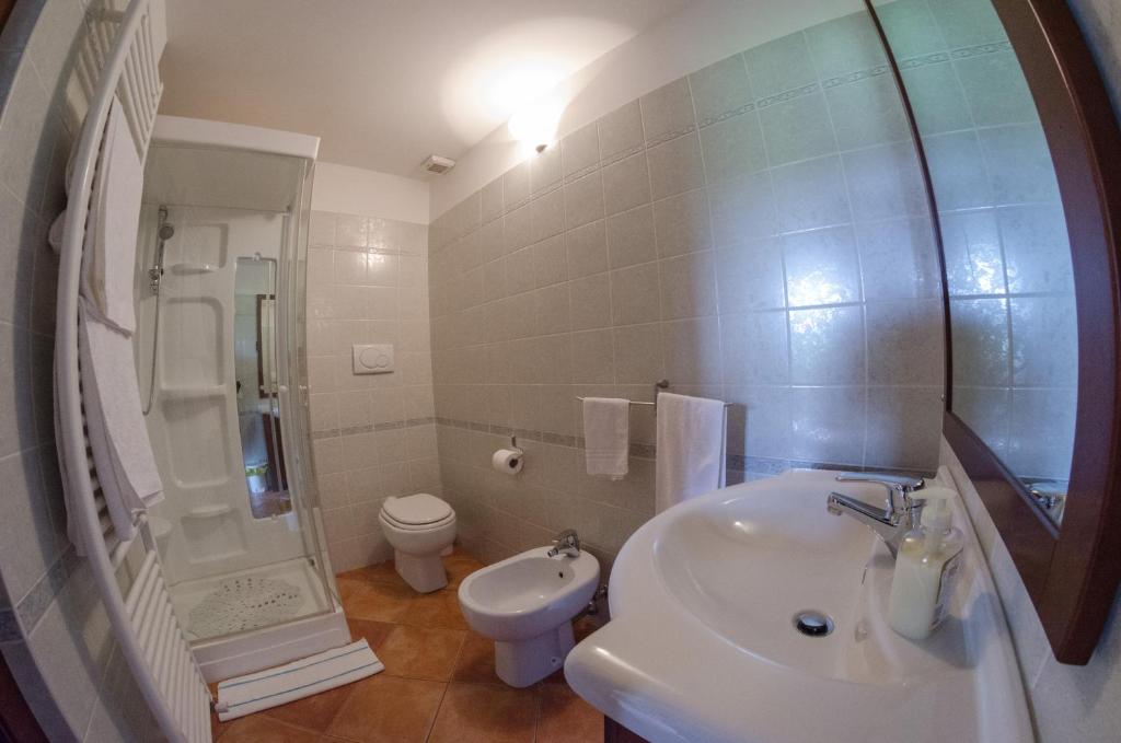 biała łazienka z umywalką i toaletą w obiekcie Villa le Vigne w mieście Loro Piceno