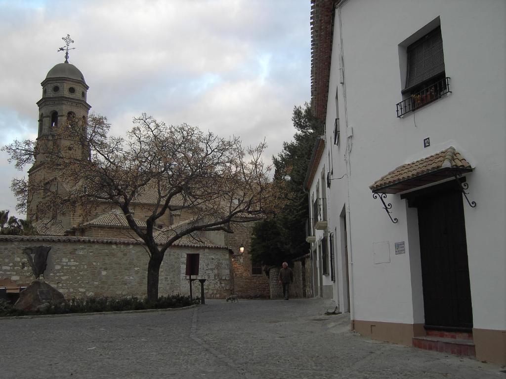 budynek z wieżą i kościół z drzewem w obiekcie Casa Rural El Arcediano w mieście Baeza