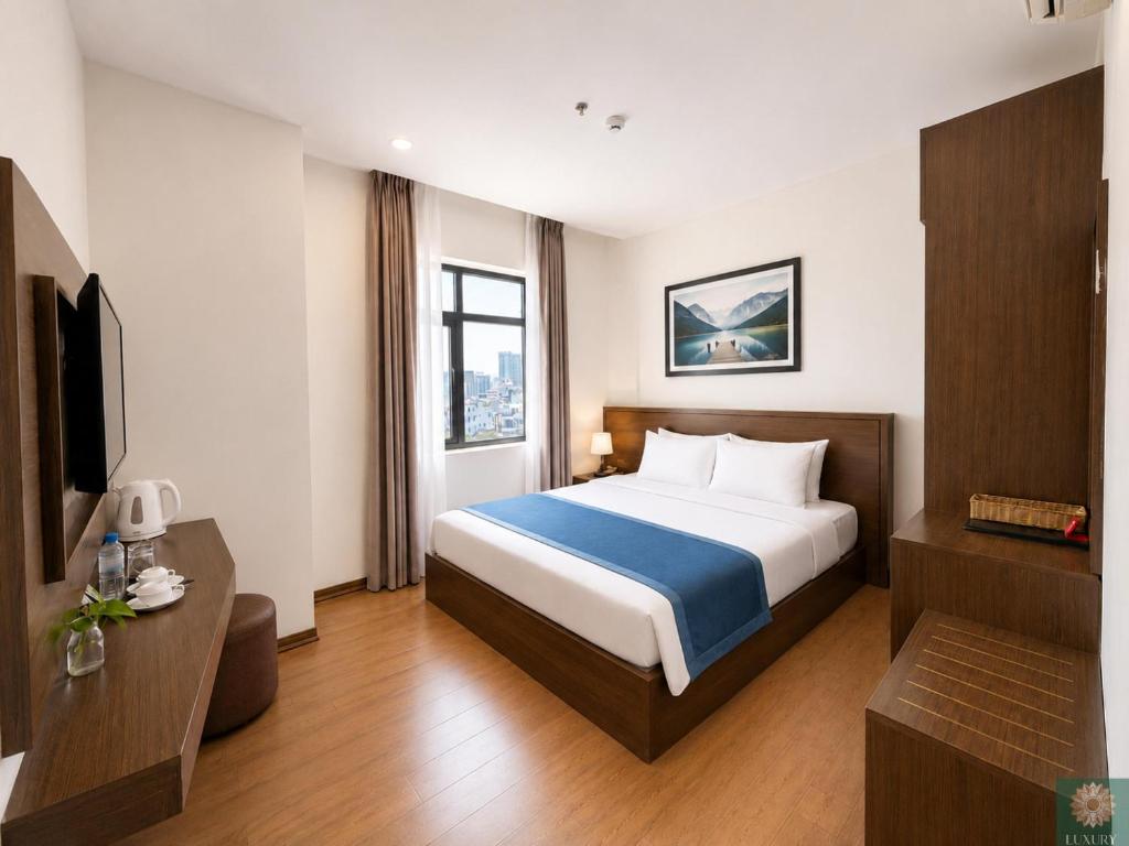 a hotel room with a bed and a television at Corner Central Danang City Hotel in Danang