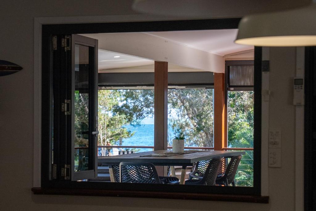 a dining room mirror with a table and chairs in front of a window at Amity Escape - Sleeps 14 in Amity Point