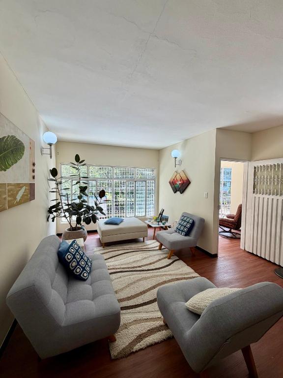a living room with two couches and a rug at Hostal Beko in Cali