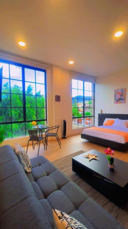 a living room with a couch and a bed at Mumbai SkyLine Luxury Suite in Quito