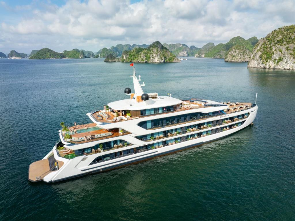 a cruise ship in the water with mountains in the background at Azura Cruise in Ha Long