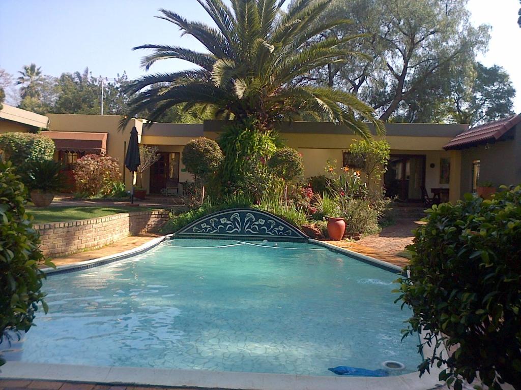 a large swimming pool in front of a house at Jubilee Lodge Guest House in Johannesburg