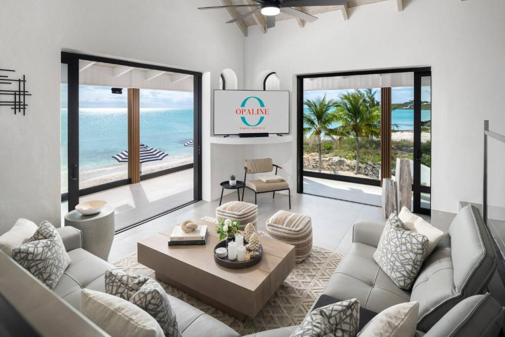 a living room with white furniture and a view of the ocean at Opaline Villa 4BR 2Bath-Ocean Front in Providenciales
