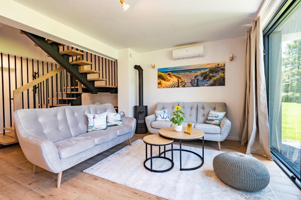 a living room with a couch and a table at Ostoja Lubiatowo in Lubiatowo
