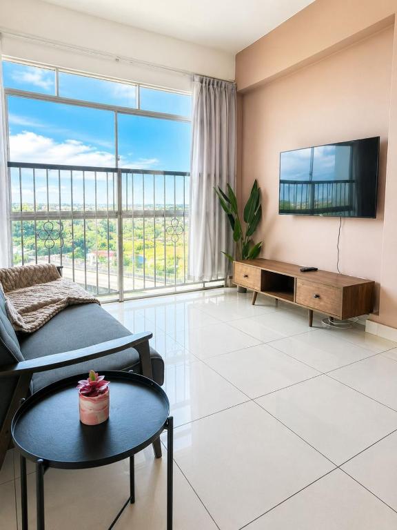 a living room with a couch and a tv at Taiping Centre Point Suite 7 by BWC in Taiping