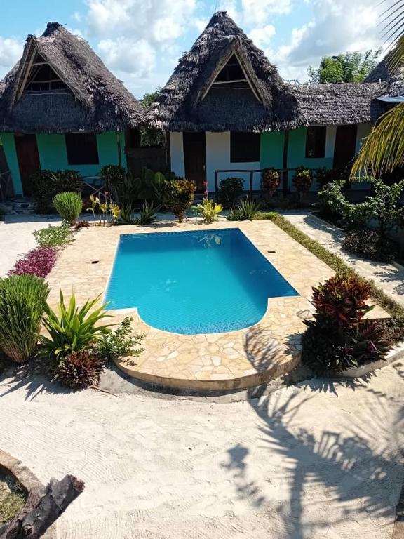a resort with a swimming pool in front of a building at Sweet Home in Kiwengwa