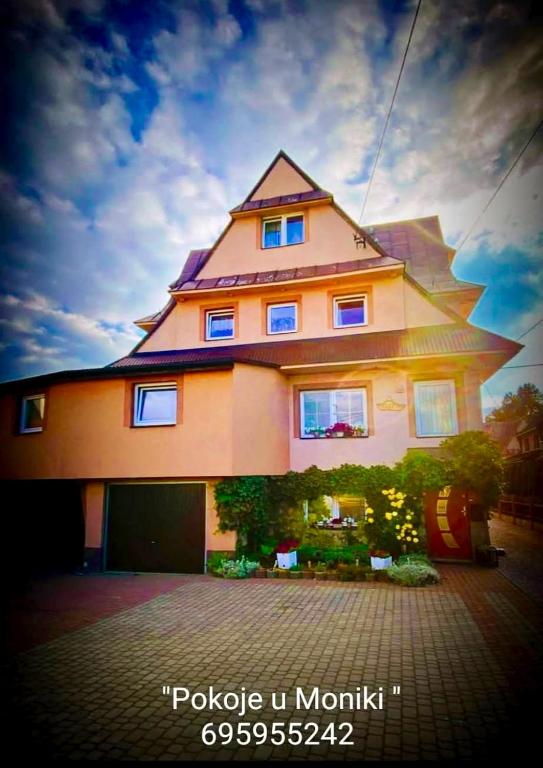 a large house with a large gambrel at Pokoje "U Moniki" in Ząb