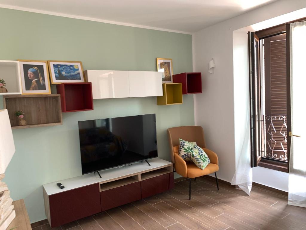 a living room with a flat screen tv and a chair at Casa vacanza Gea - Superior Apartment in Bergamo city with private parking car in Bergamo
