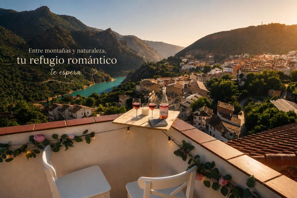 a table with two glasses of wine on a balcony at Studio with Terrace & Stunning Views in Güéjar-Sierra