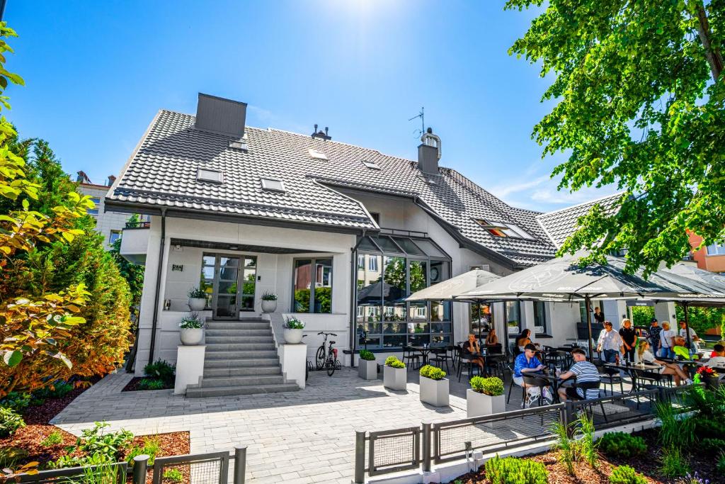 a house with people sitting outside of it at Vila Ieva in Palanga