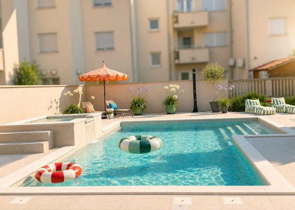 a swimming pool with two beach balls and an umbrella at Villa Vida, Medulin - Bazen i jacuzzi in Medulin
