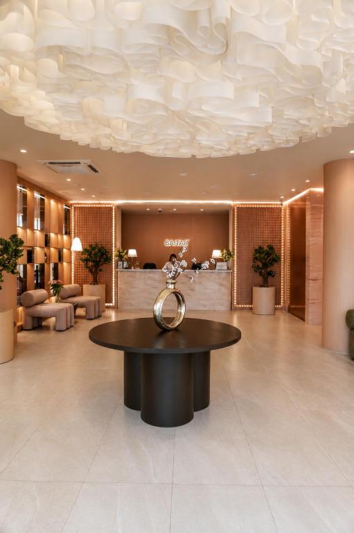 a lobby with a circular table in the middle at Baitau Hotel Aktobe in Aktobe