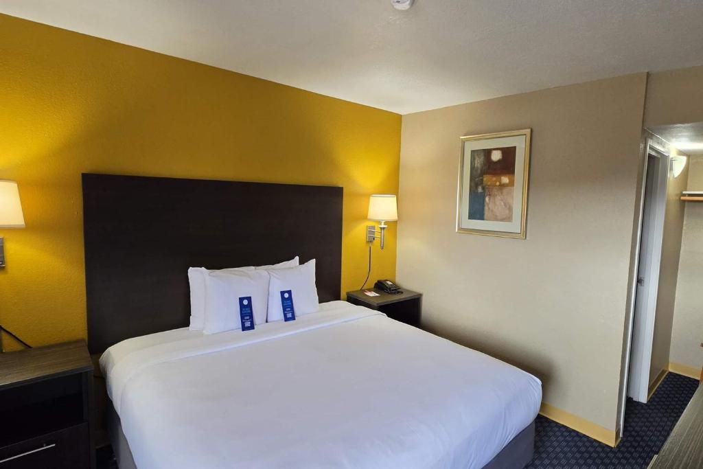 a large white bed in a room with yellow walls at Howard Johnson by Wyndham Odessa TX in Odessa