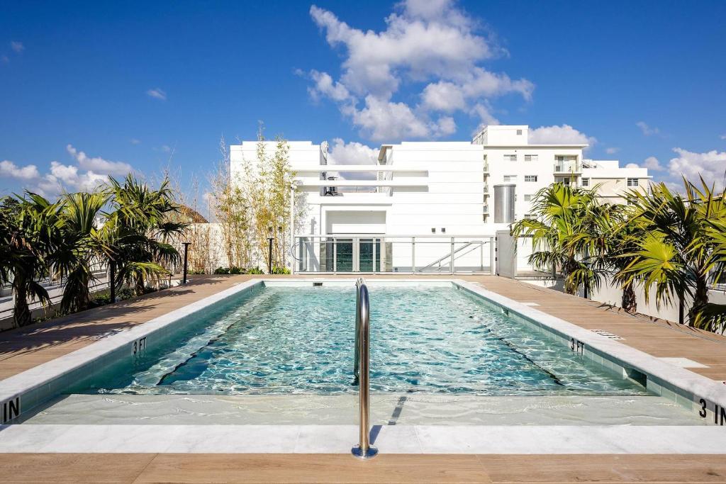 a swimming pool in front of a white building at Dolce by Wyndham Miami Beach in Miami Beach