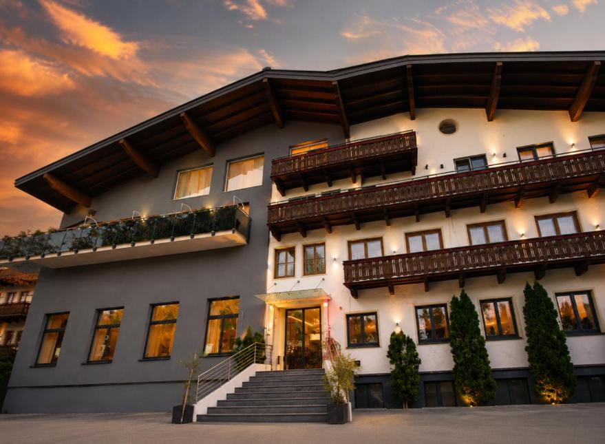 a large white building with stairs in front of it at Thurners Boutique Hotel at Großglockner, Film Inspired in Bruck an der Großglocknerstraße