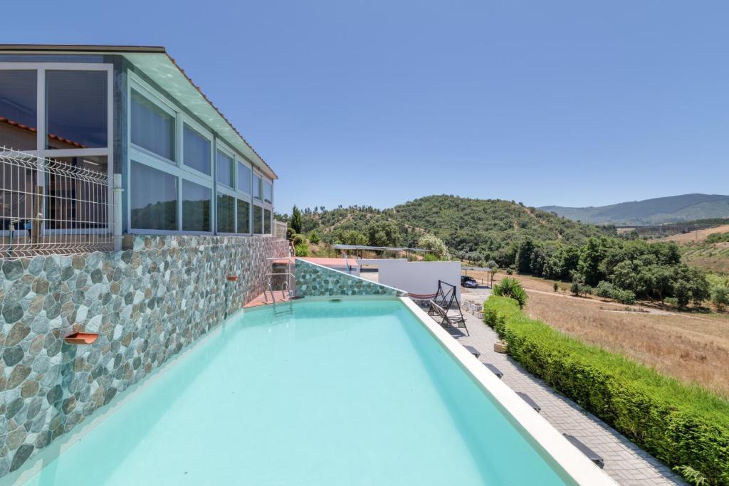 a villa with a swimming pool and a house at Monte Corte Enchária in São Teotónio