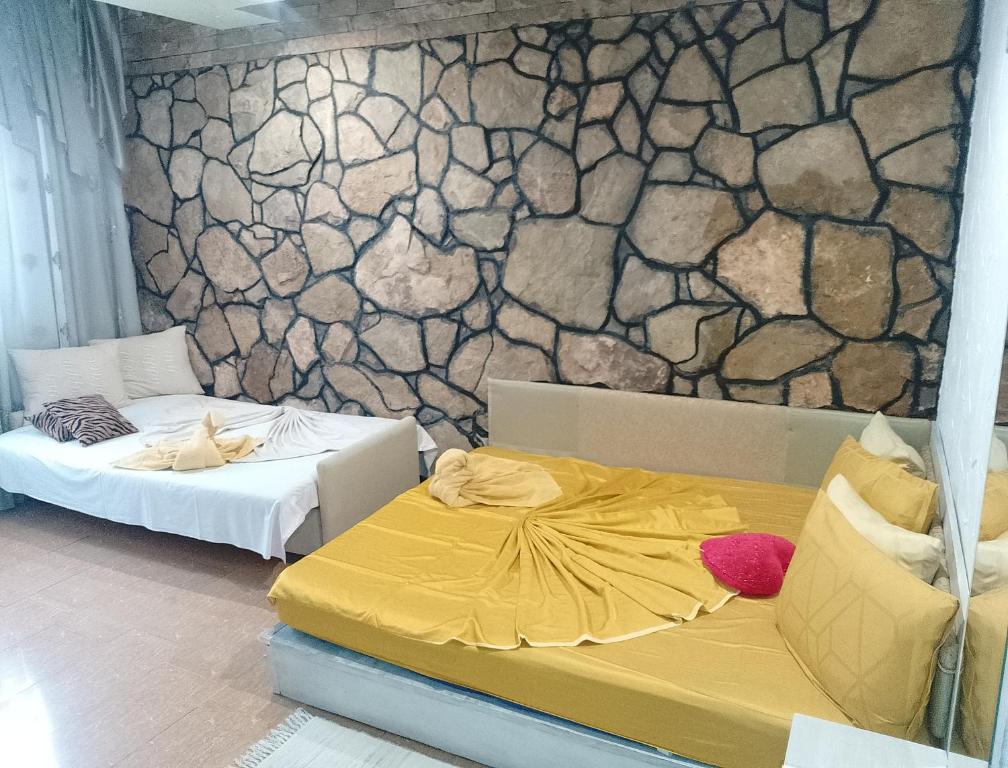 a room with two beds and a stone wall at Samaya in Agigea
