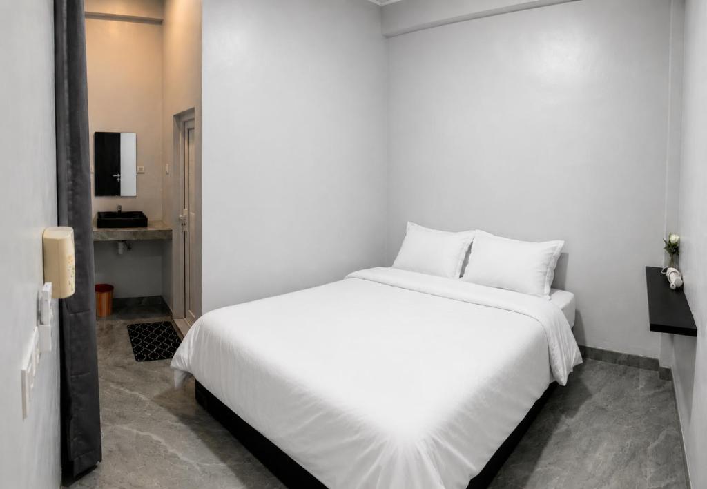 a bedroom with a large white bed with white sheets at Teupin Layeu Hotel in Iboih