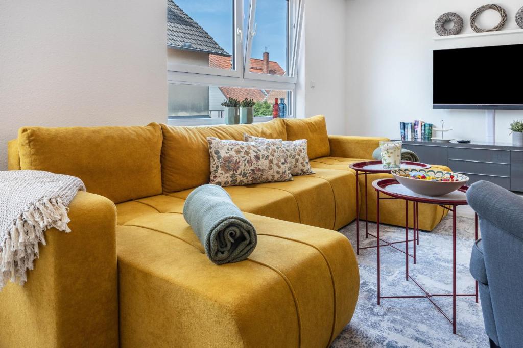 a living room with a yellow couch and a table at To Huus am Steinhuder Meer in Steinhude