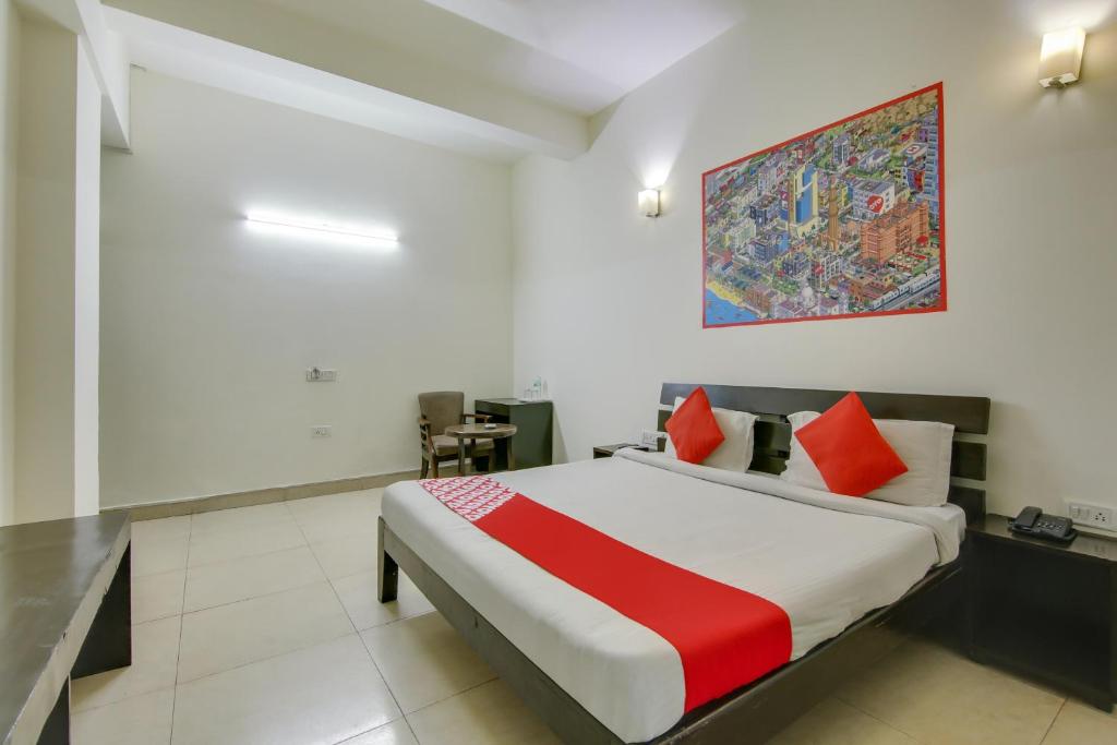 a bedroom with a bed with a red and white blanket at Hotel O Dream View in Gurgaon