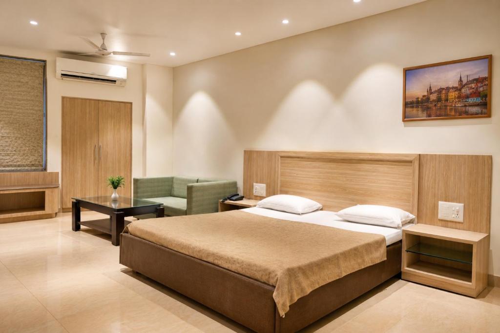 a hotel room with a bed and a chair at Hotel Bagla Atithi Banaras in Varanasi