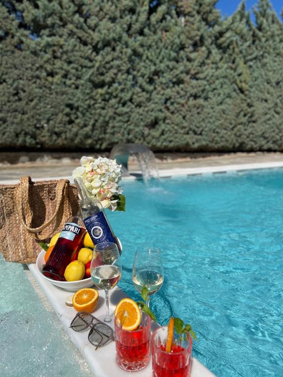a table with wine glasses and drinks next to a swimming pool at Two Bedroom Villa with Private Pool & Garden by Olivujoj in Anavyssos
