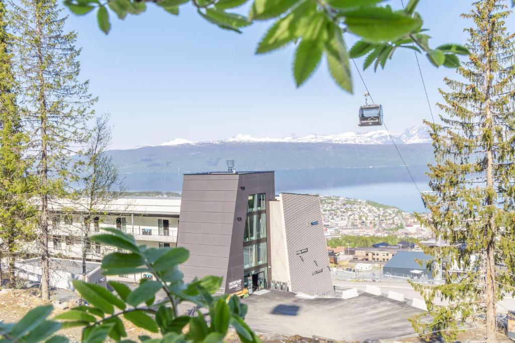 a building with a ski lift in front of a mountain at Basecamp Narvik in Narvik
