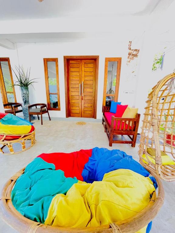a large colorful bed in a room with chairs at Kumudu Holiday Home in Hiriketiya