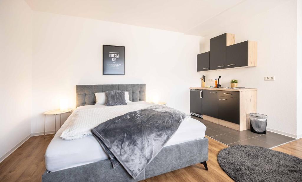 a bedroom with a large bed and a kitchen at N4 - Apartments Fulda Free Parking & Zentral in Fulda