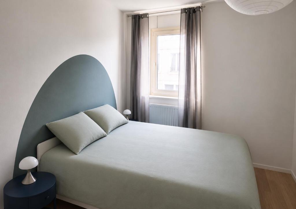 a bedroom with a large bed with a large window at Le Nid Didier in Saint-Didier-en-Velay