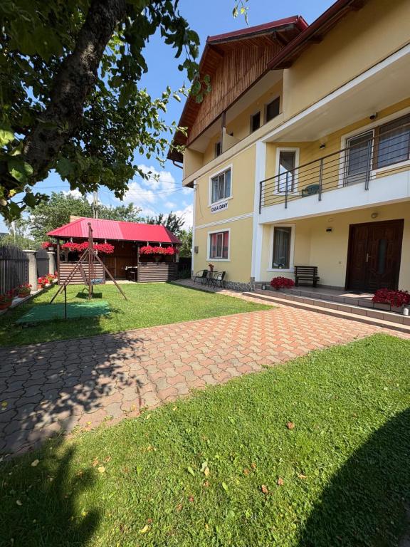 a building with a playground in front of a yard at Casa Dany in Vatra Dornei