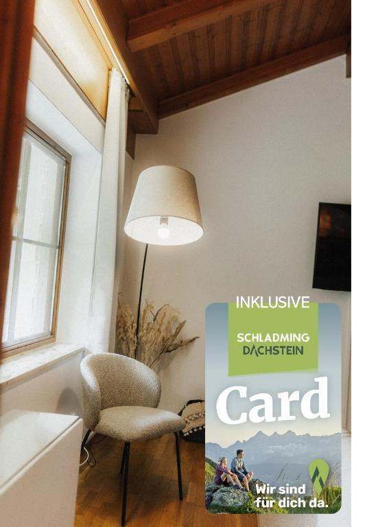 a chair and a lamp in a room with a book at City Bungalow in Schladming