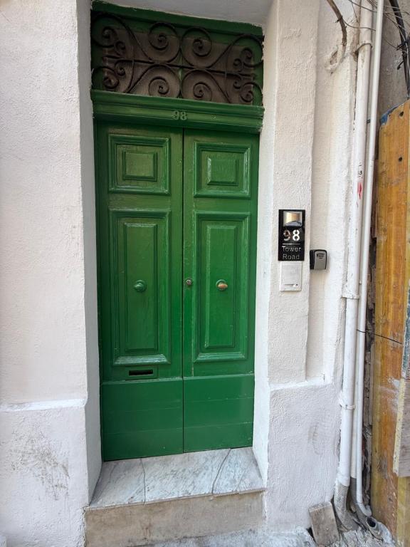 a green door on the side of a building at Arantza House in Sliema
