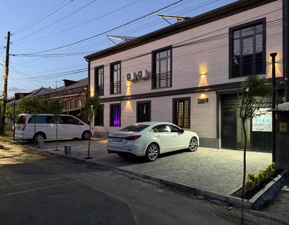 Ein weißes Auto parkte vor einem Gebäude in der Unterkunft Memory Apart Hotel in Yerevan