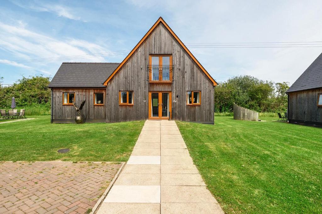 a large wooden house on a grassy field at Charcoal Lodge in Brigg