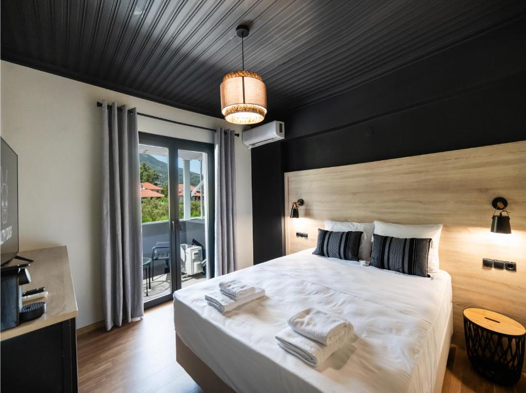 a bedroom with a large bed with towels on it at Salty Dog Suites in Vasiliki