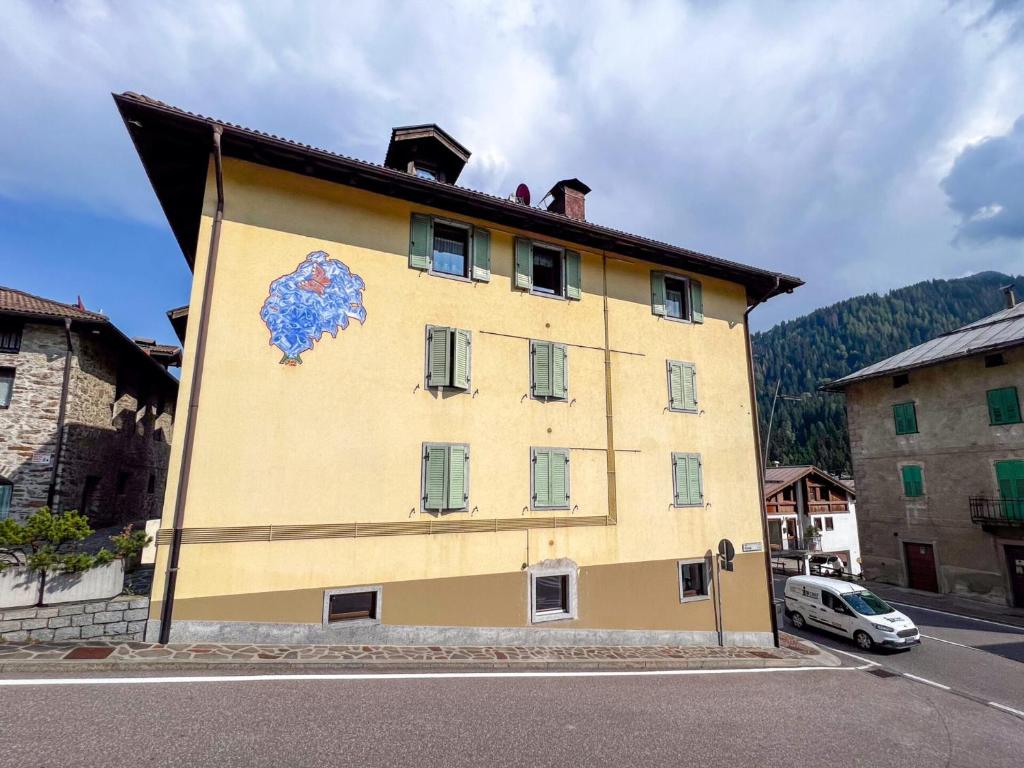 a yellow building with a painting on the side of it at Palazzina Carola in Mezzana