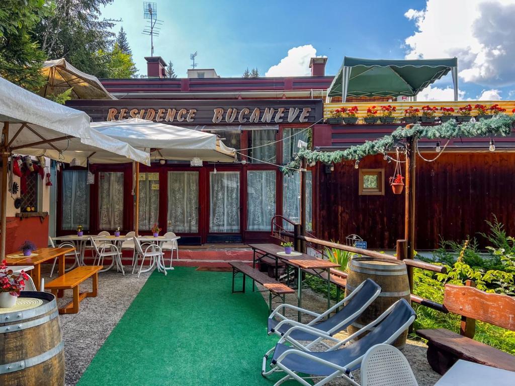 a patio with chairs and tables in front of a building at Residence Bucaneve in Mezzana