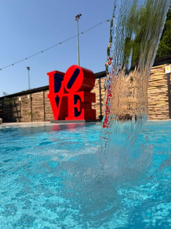 a water fountain in a swimming pool with the word ego at Paradisea club and residences in Volla