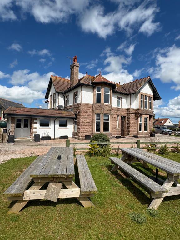 two picnic tables in front of a house at St Olaf Golf Hotel in Cruden Bay