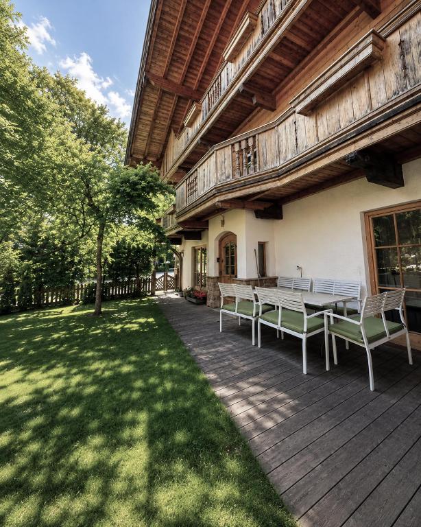 a wooden deck with a table and chairs in a yard at Center Chalet in Mayrhofen