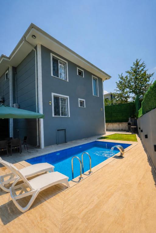 a swimming pool in front of a house at Antonelya Home in Sapanca