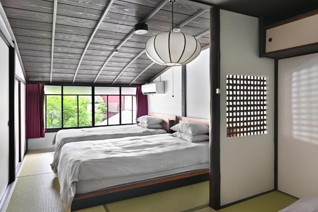 a bedroom with a large bed and a large window at ann長良 Machiya Private Villa ann Nagara 築130年古民家で長良川と岐阜城を満喫 無料駐車場4台完備 無人チェックイン in Gifu